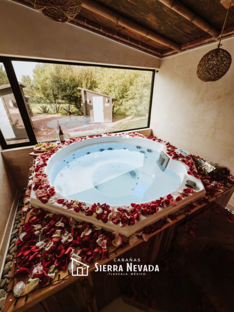 Jacuzzi en experiencia romántica y al fondo glamping minicabaña, Sierra Nevada, Tlaxcala